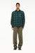 Male model wearing a BLUEMARBLE green and navy checked shirt in brushed cotton flannel, featuring rhinestone raindrop embellishments across the front, a slightly oversized fit and front button closure, styled with olive green trousers and black shoes against a white studio background.